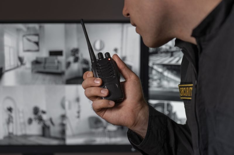 retrato-de-guardia-de-seguridad-masculino-con-estacion-de-radio-y-pantallas-de-camara retrato-de-guardia-de-seguridad-masculino-con-estacion-de-radio-y-pantallas-de-camara